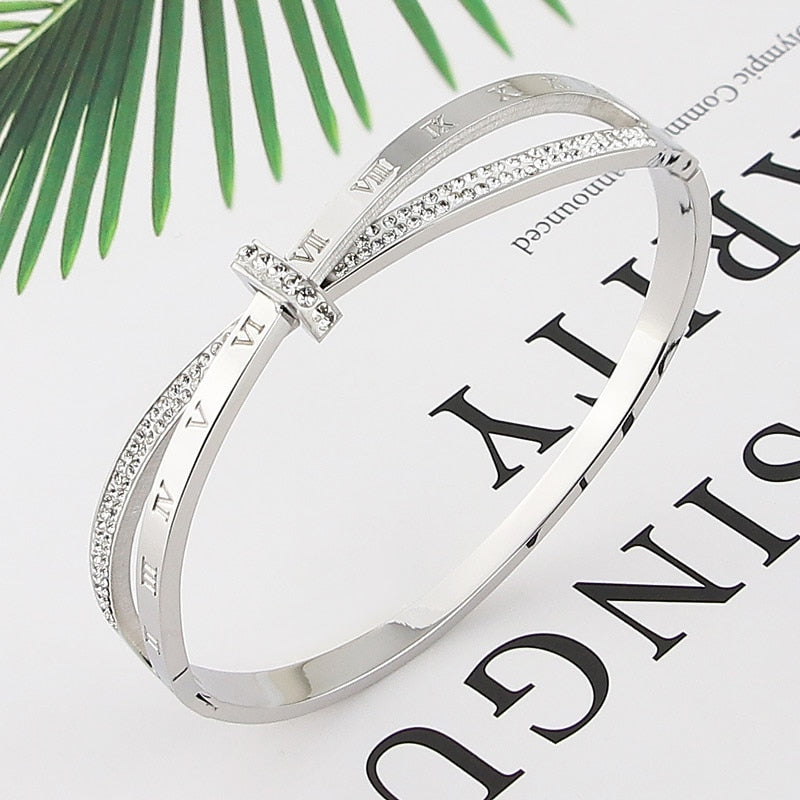 Shapely letters adorn this stainless steel bangle, a timeless accessory that flatters all outfits! The perfect complement to every wardrobe, this fashionable bangle is sure to make a statement.
