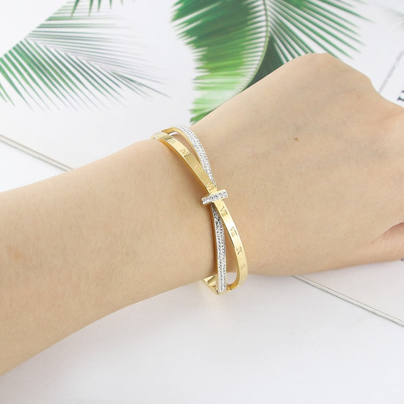 Shapely letters adorn this stainless steel bangle, a timeless accessory that flatters all outfits! The perfect complement to every wardrobe, this fashionable bangle is sure to make a statement.
