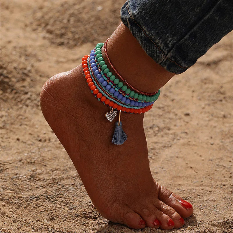 This anklet set features a Y2K style ankle bracelet set designed for women to wear during the summer at the beach. The anklets are hand-woven and adorned with colorful beads for a trendy look.