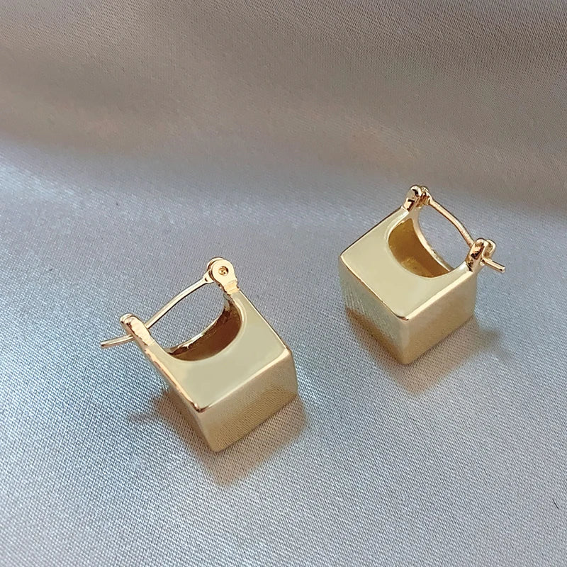 Elevate your fashion game with these exquisite gold-colored pendant earrings. Designed in a simple cubic shape, these accessories are perfect for women who want to make a statement at weddings or parties. Whether you're in Europe or America, these earrings will add a touch of elegance to your fashion style.