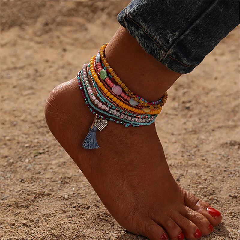 This anklet set features a Y2K style ankle bracelet set designed for women to wear during the summer at the beach. The anklets are hand-woven and adorned with colorful beads for a trendy look.
