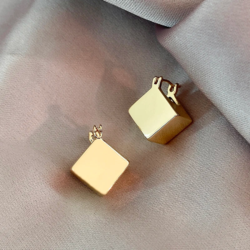 Elevate your fashion game with these exquisite gold-colored pendant earrings. Designed in a simple cubic shape, these accessories are perfect for women who want to make a statement at weddings or parties. Whether you're in Europe or America, these earrings will add a touch of elegance to your fashion style.