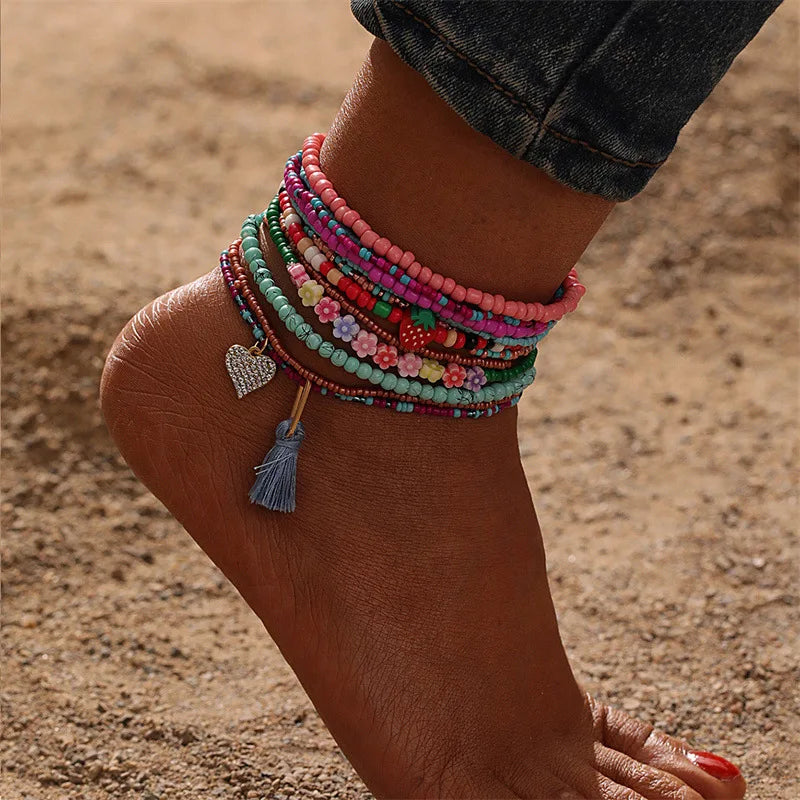 This anklet set features a Y2K style ankle bracelet set designed for women to wear during the summer at the beach. The anklets are hand-woven and adorned with colorful beads for a trendy look.