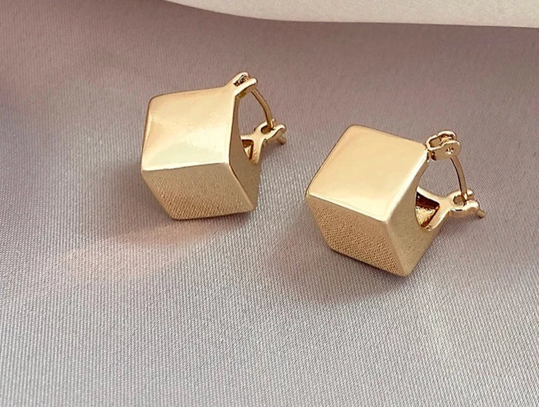 Elevate your fashion game with these exquisite gold-colored pendant earrings. Designed in a simple cubic shape, these accessories are perfect for women who want to make a statement at weddings or parties. Whether you're in Europe or America, these earrings will add a touch of elegance to your fashion style.