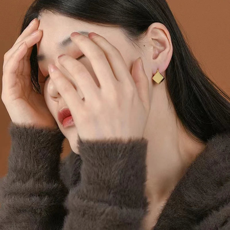 Elevate your fashion game with these exquisite gold-colored pendant earrings. Designed in a simple cubic shape, these accessories are perfect for women who want to make a statement at weddings or parties. Whether you're in Europe or America, these earrings will add a touch of elegance to your fashion style.