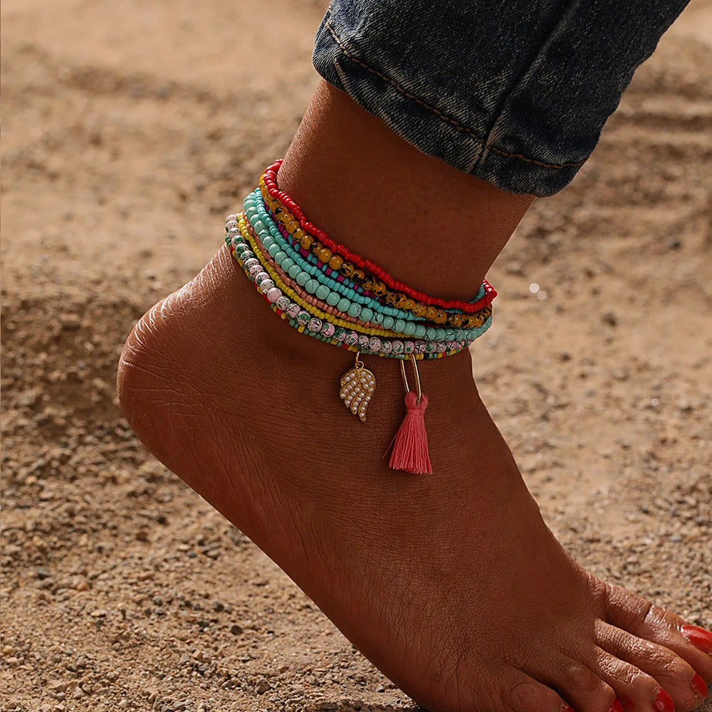 This anklet set features a Y2K style ankle bracelet set designed for women to wear during the summer at the beach. The anklets are hand-woven and adorned with colorful beads for a trendy look.