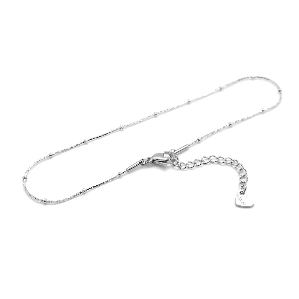This anklet is made of 304 stainless steel and features a round heart chain design in a silver color, perfect for women to wear during the summer at the beach.