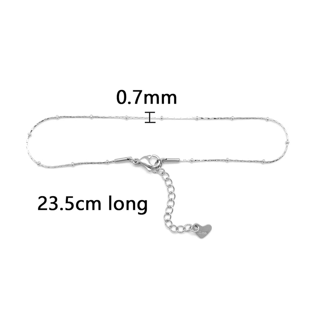 This anklet is made of 304 stainless steel and features a round heart chain design in a silver color, perfect for women to wear during the summer at the beach.
